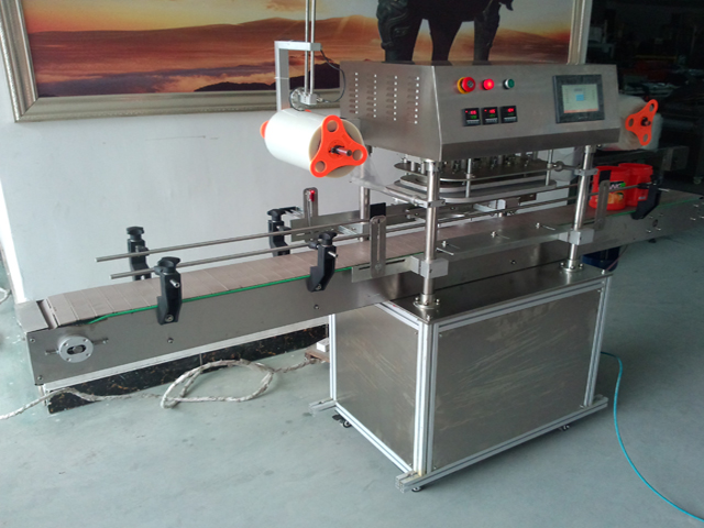 side pictures for automatic jars sealing machine آلة الختم في التشغيل.jpg