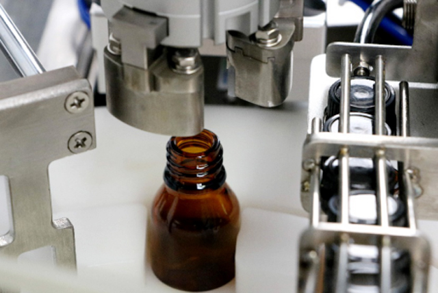 آلة تعبئة زجاجات الزيت على الطاولة.jpg